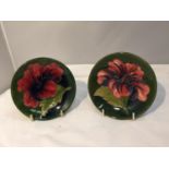 A PAIR OF MOORCROFT HIBISCUS ON GREEN PIN DISHES