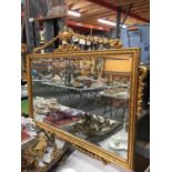 A LARGE GILT FRAMED VINTAGE STYLE BEVELLED GLASS MIRROR WITH DECORATION TO THE TOP 91CM X 61CM