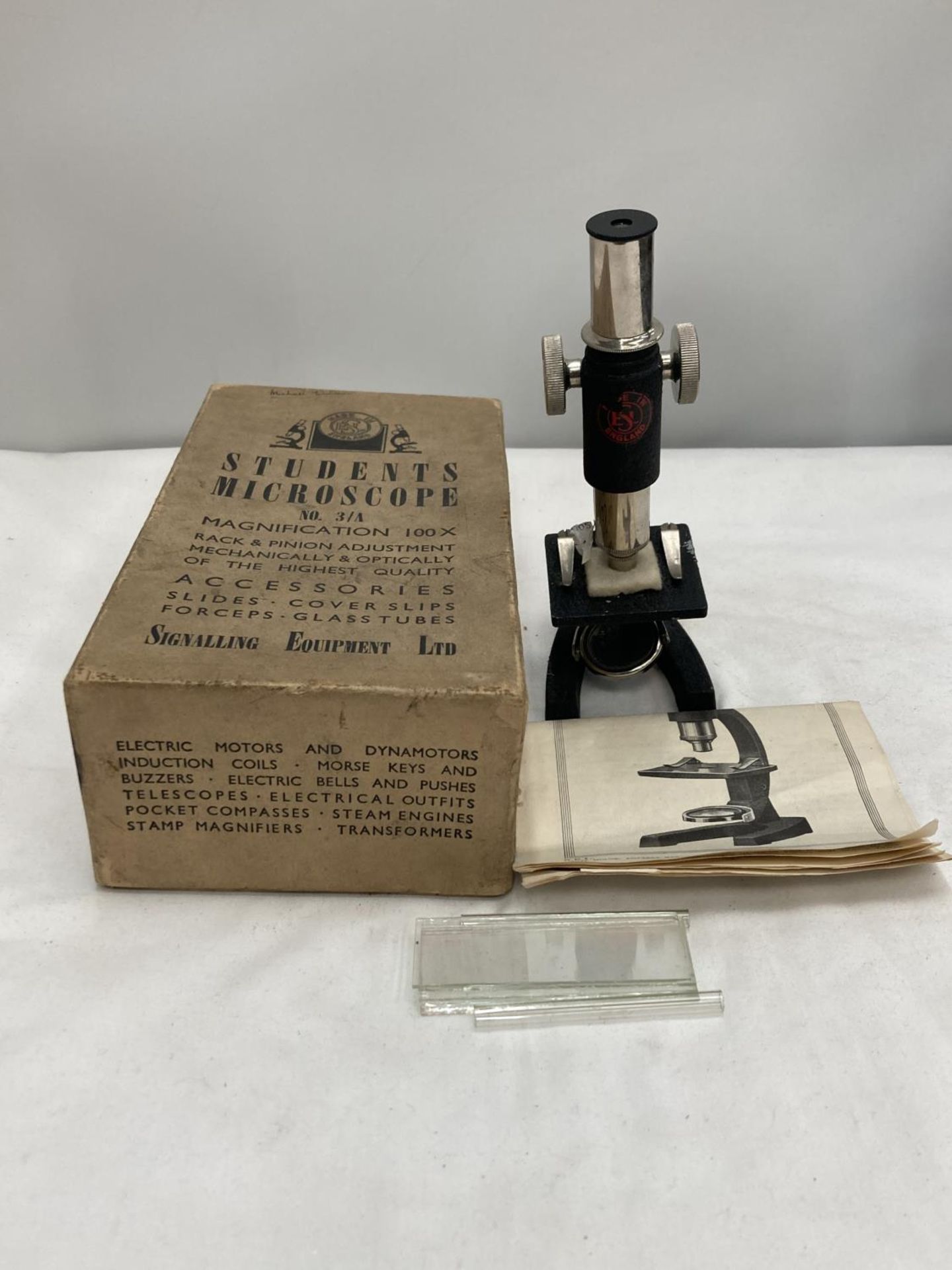 A BOXED STUDENTS MICROSCOPE MADE BY SIGNALLING EQUIPMENT LIMITED