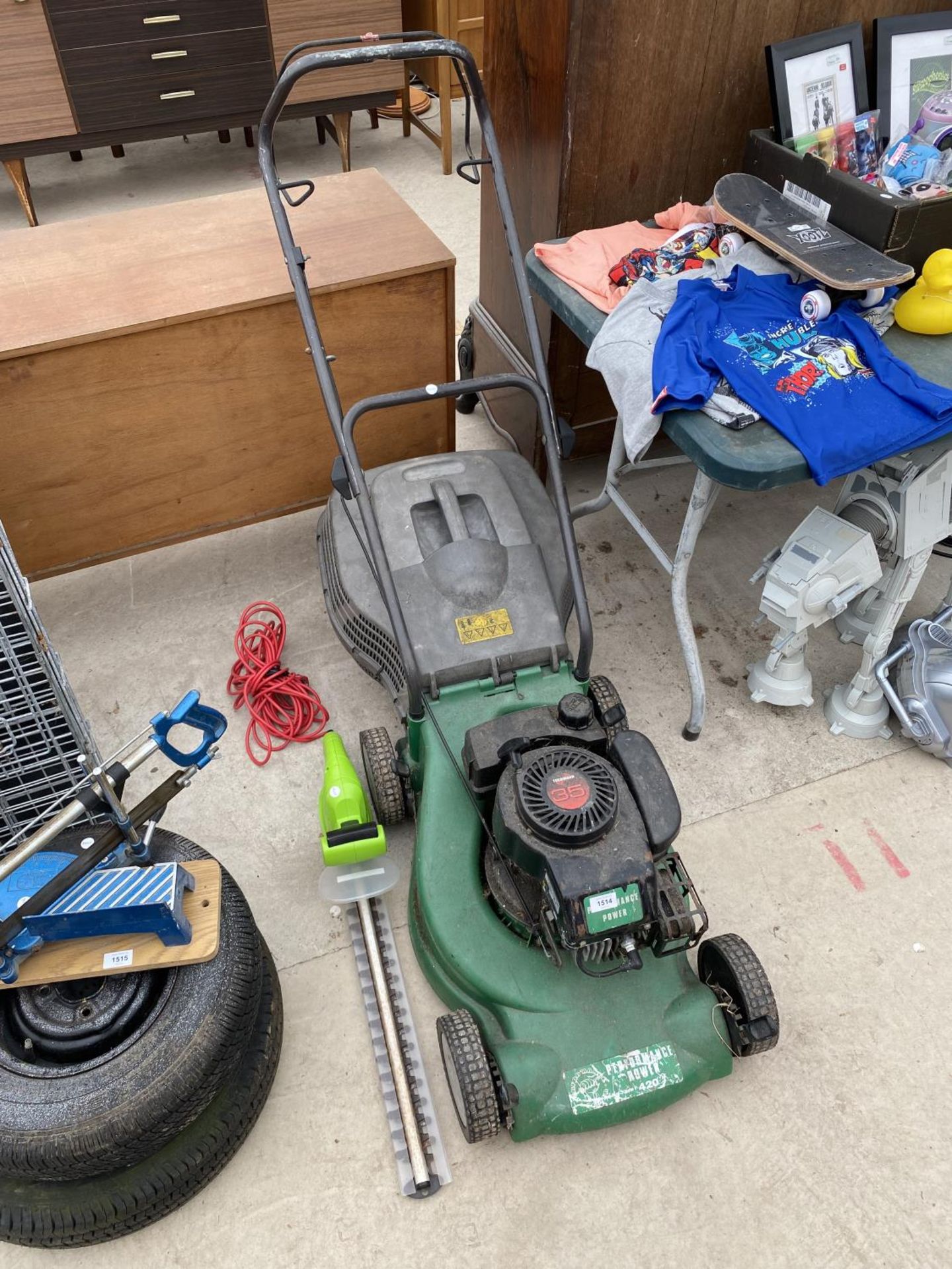 A PERFORMANCE POWER PWTROL LAWN MOWER AND AN ELECTRIC HEDGE TRIMMER
