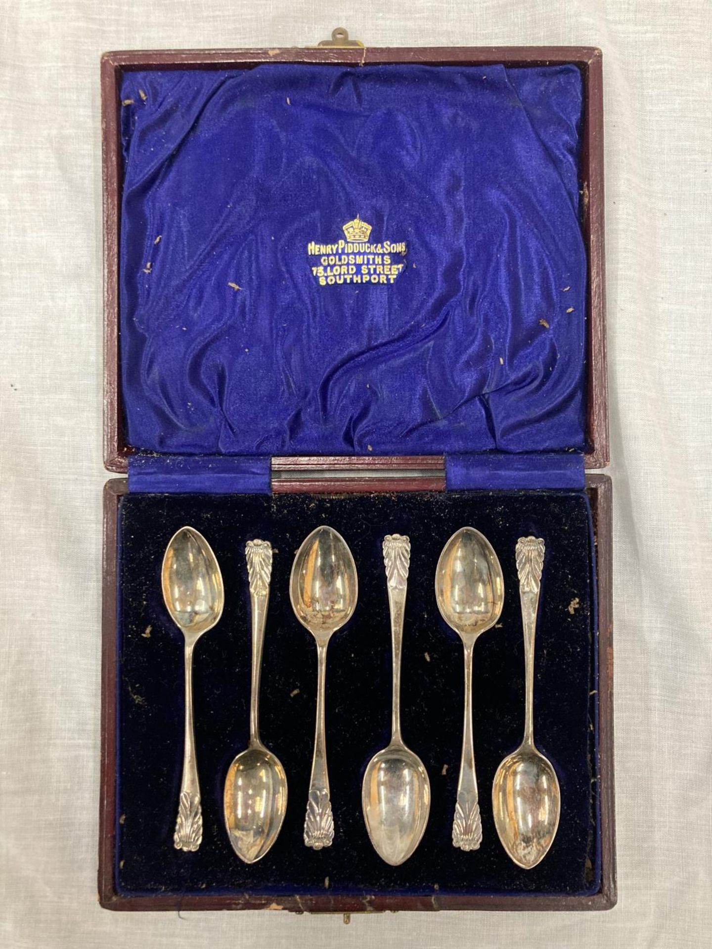 SIX HALLMARKED SHEFFIELD TEASPOONS IN A LEATHER BOX WITH THE NAME, HENRY PIDDUCK & SONS