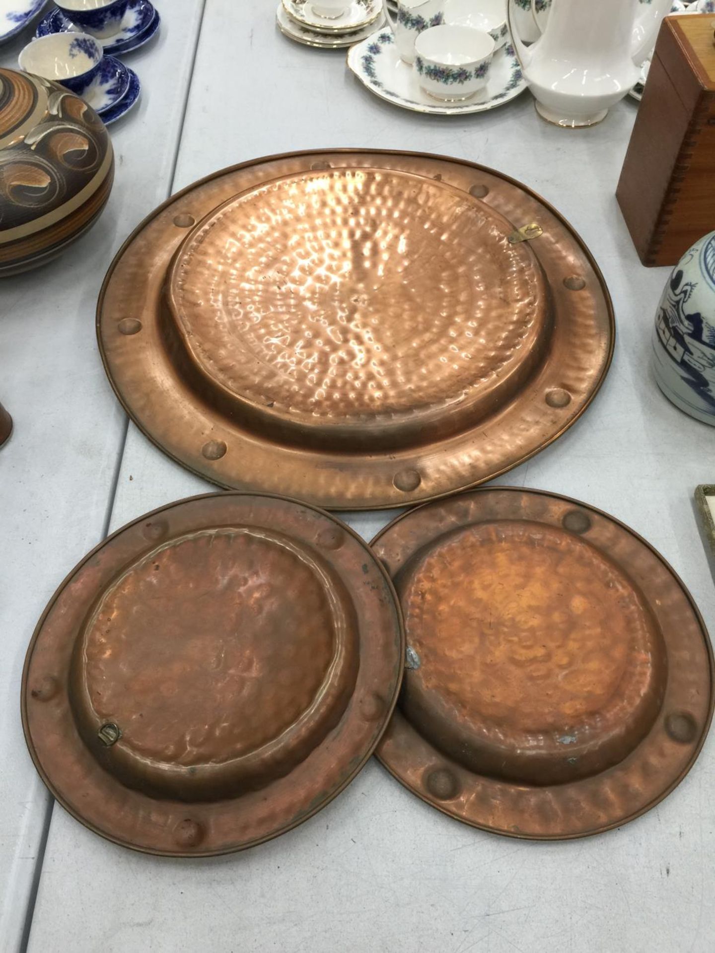 A LARGE AND TWO SMALLER HAND HAMMERED COPPER CHARGERS DIAMETERS 53CM AND 29CM - Image 2 of 2