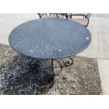 A DECORATIVE WROUGHT IRON BASED ROUND GARDEN PATIO TABLE WITH GRANITE TOP