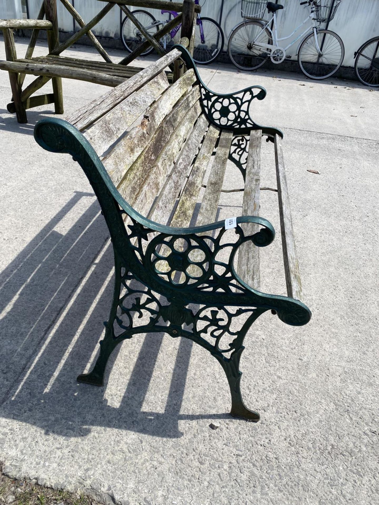 A WOODEN SLATTED GARDEN BENCH WITH DECORATIVE CAST ENDS - Image 2 of 3