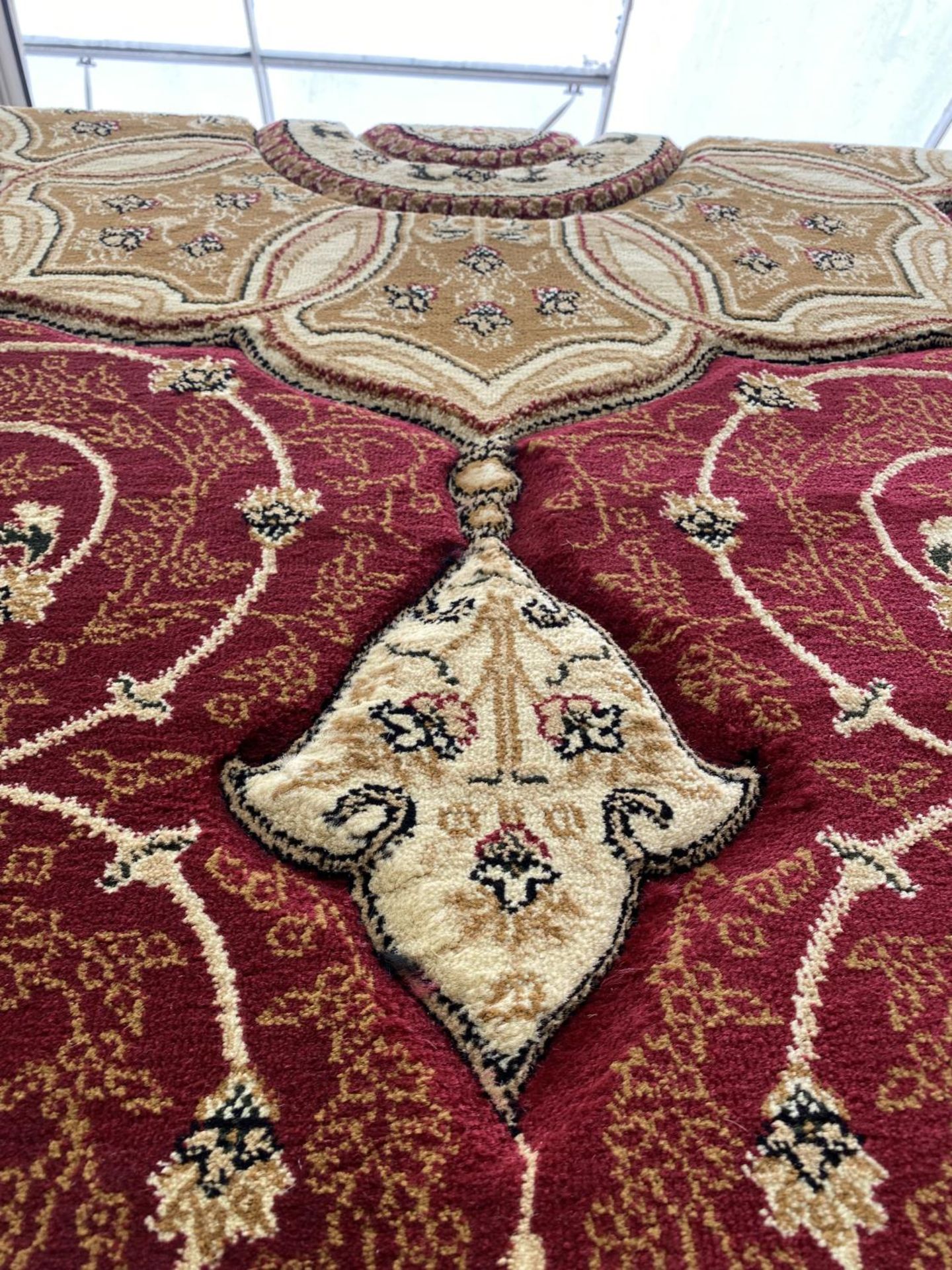 A LARGE RED AND CREAM PATTERNED RUG - Image 5 of 5