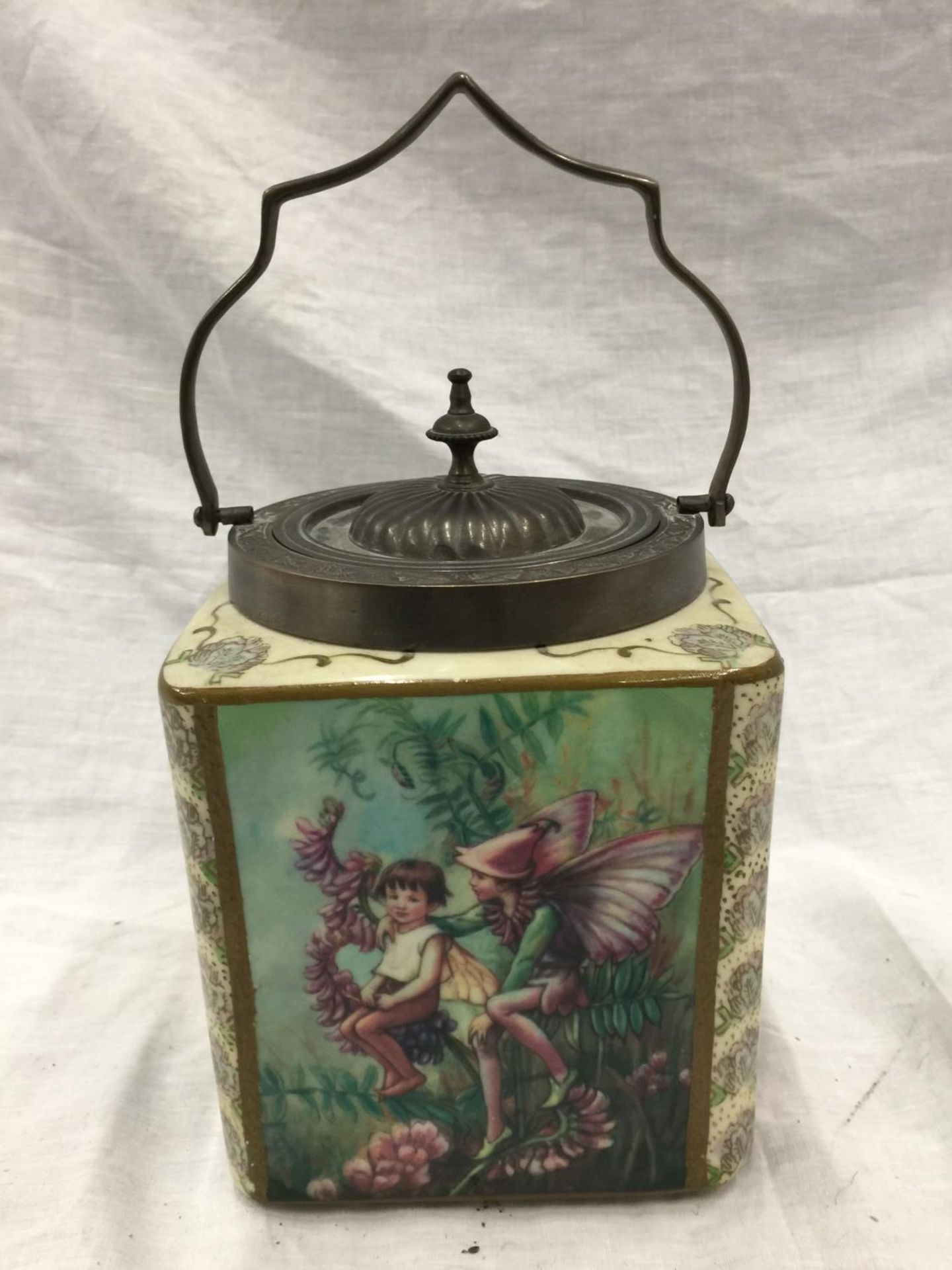 A BISCUIT BARREL WITH FAIRIES AND FLOWERS DESIGN TO PANELS AND A PEWTER LID AND HANDLE WITH CARLTONS