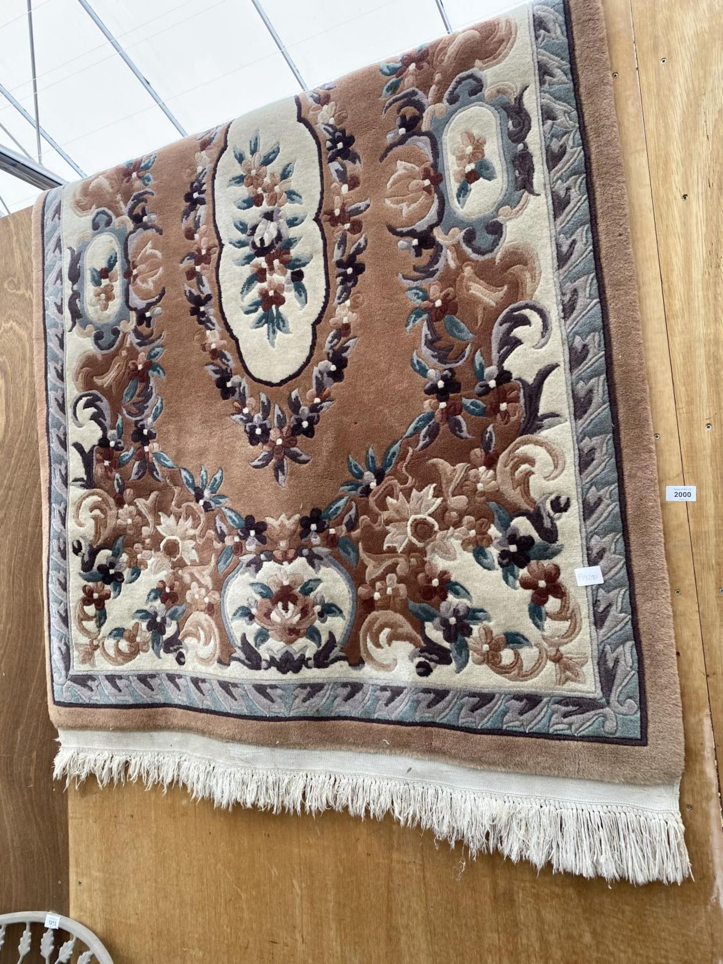 AN ORANGE PATTERNED FRINGED RUG