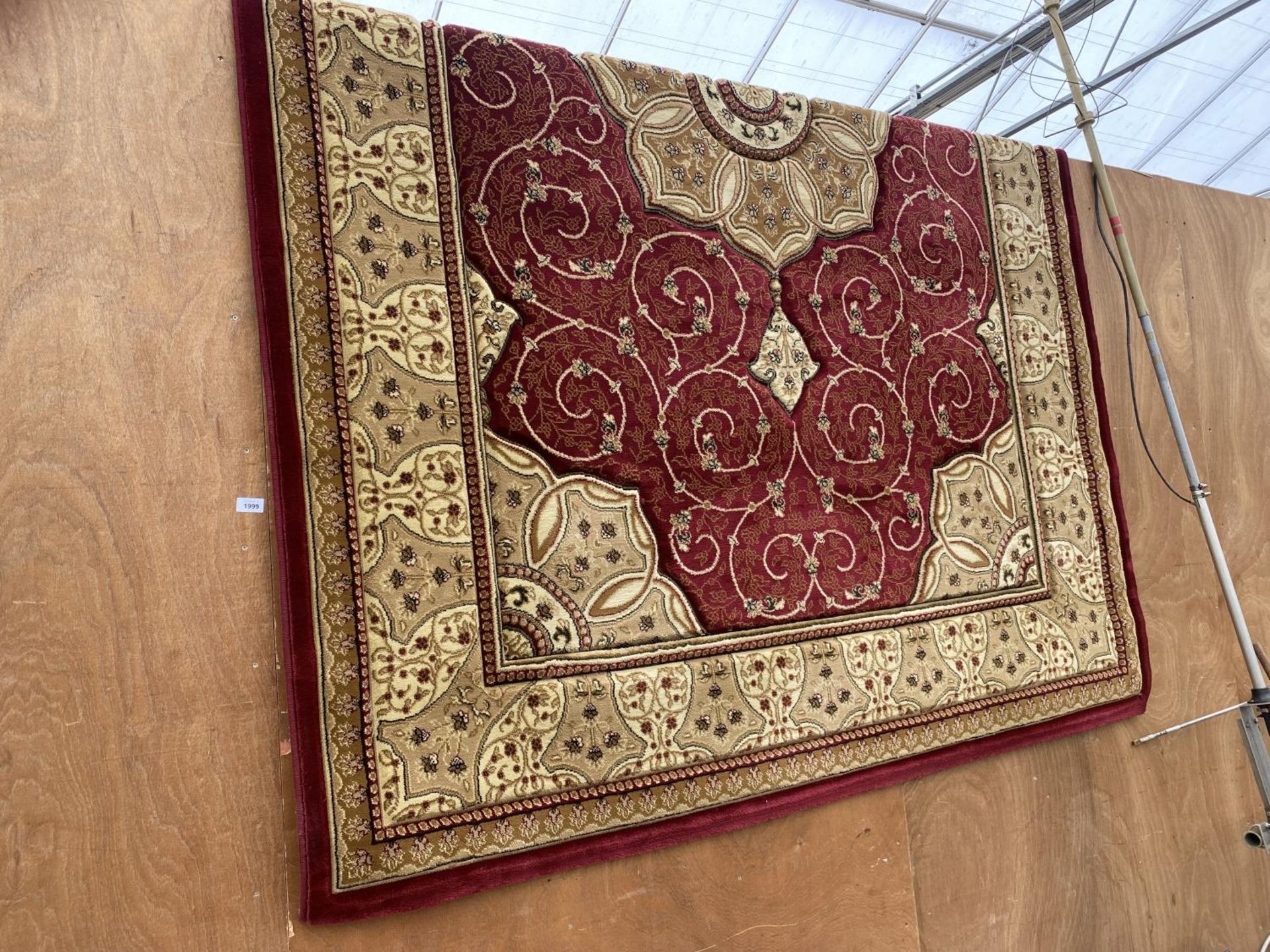 A LARGE RED AND CREAM PATTERNED RUG