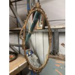 A VINTAGE STYLE GILT FRAMED OVAL MIRROR 66CM X 36CM APPROX