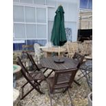 AN OCTAGONAL WOODEN GARDEN TABLE WITH FOUR CHAIRS AND A PARASOL