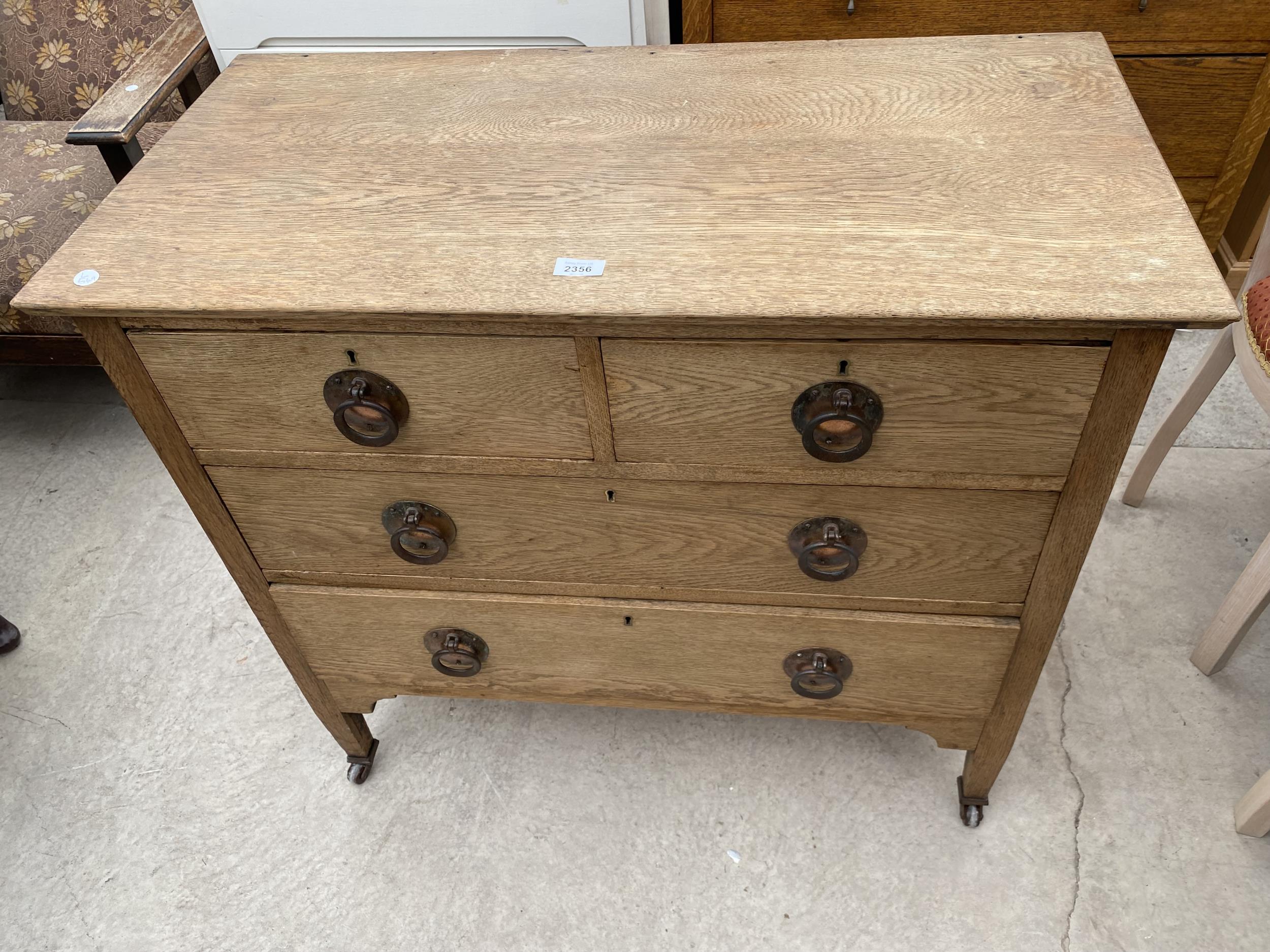 AN OAK ART NOUVEAU CHEST OF TWO SHORT AND TWO LONG DRAWERS, 36" WIDE, WITH COPPERISED HANDLES