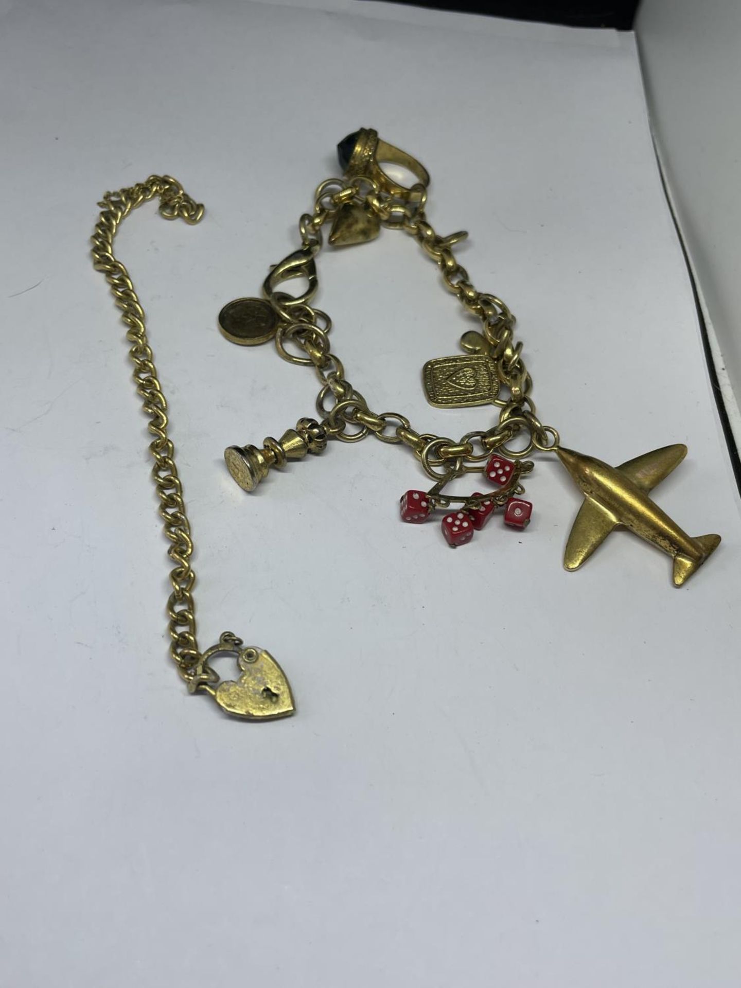 TWO YELLOW METAL BRACELETS TO INCLUDE ONE WITH EIGHT CHARMS