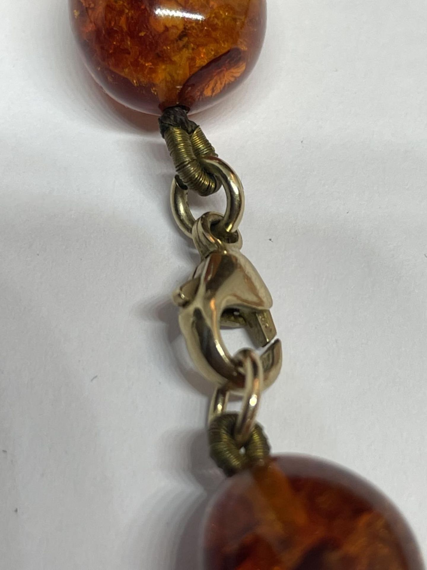 A KNOTTED AMBER NECKLACE WITH A MARKED 9K CLASP - Image 3 of 4