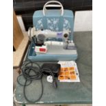 A RETRO JONES SEWING MACHINE WITH WORK LIGHT, FOOT PEDAL AND CARRY CASE