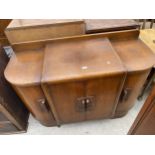 AN OAK ART DECO BOW ENDED SIDEBOARD WITH FOUR CUPBOARDS, THE CENTRE TWO HAVING THREE INTERNAL