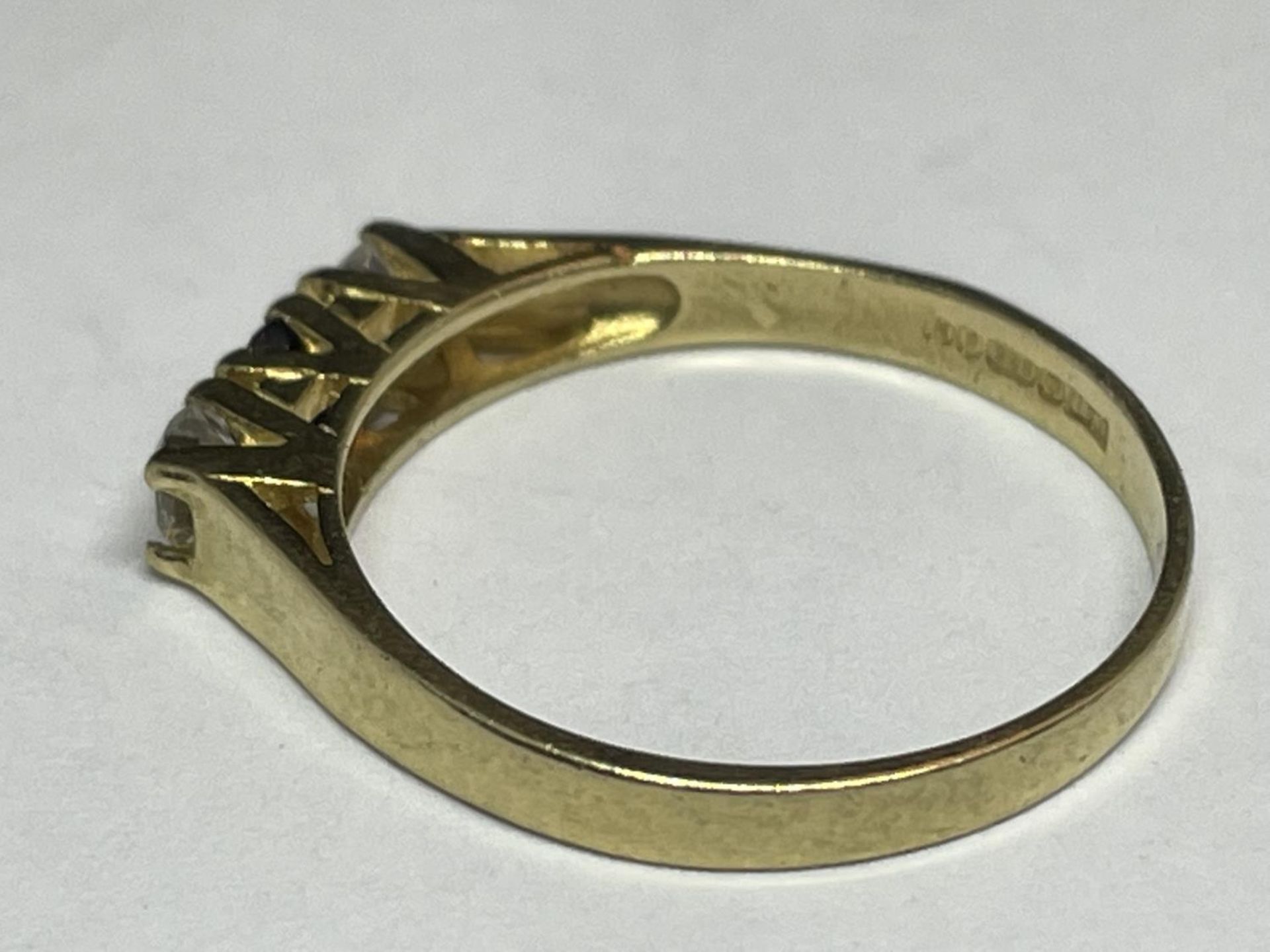 A 9 CARAT GOLD RING WITH THREE IN LINE STONES TO INCLUDE A CENTRE SAPPHIRE AND TWO CUBIC ZIRCONIAS - Image 3 of 8