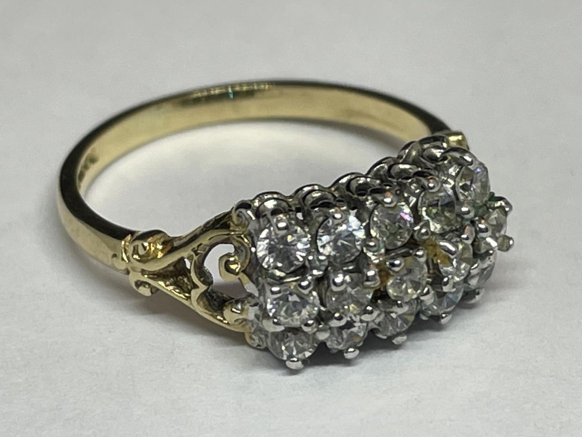 A 9 CARAT GOLD RING WITH FIFTEEN CUBIC ZIRCONIA STONES IN A CLUSTER DESIGN SIZE N