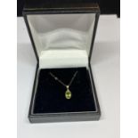 A 9 CARAT GOLD NECKLACE WITH A PERIDOT STONE PENDANT IN A PRESENTATION BOX