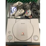A SONY PLAYSTATION 1 WITH CONTROLLERS AND GAME