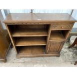 AN OAK OLD CHARM OPEN BOOKCASE ENCLOSING SINGLE DRAWER AND CUPBOARD, 37" WIDE