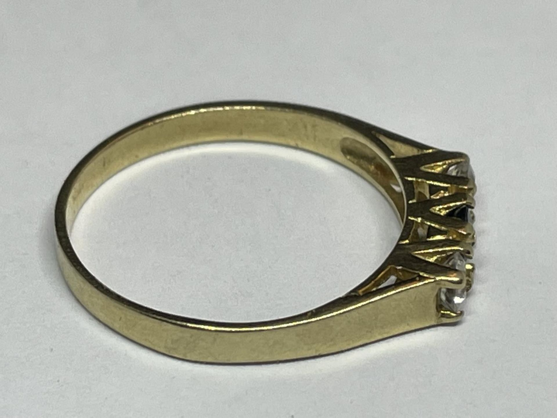 A 9 CARAT GOLD RING WITH THREE IN LINE STONES TO INCLUDE A CENTRE SAPPHIRE AND TWO CUBIC ZIRCONIAS - Image 6 of 8