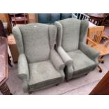 A PAIR OF GREEN H.S.L. WINGED FIRESIDE CHAIRS ON FRONT CABBRIOLE LEGS