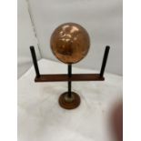 A 'ART' PIECE OF A COPPER BALL ON A WOODEN STAND