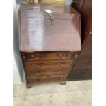 A GEORGE III OAK BUREAU OF SMALL PROPORTIONS HAVING FITTED INTERIOR, THREE GRADUATED DRAWERS, ONE