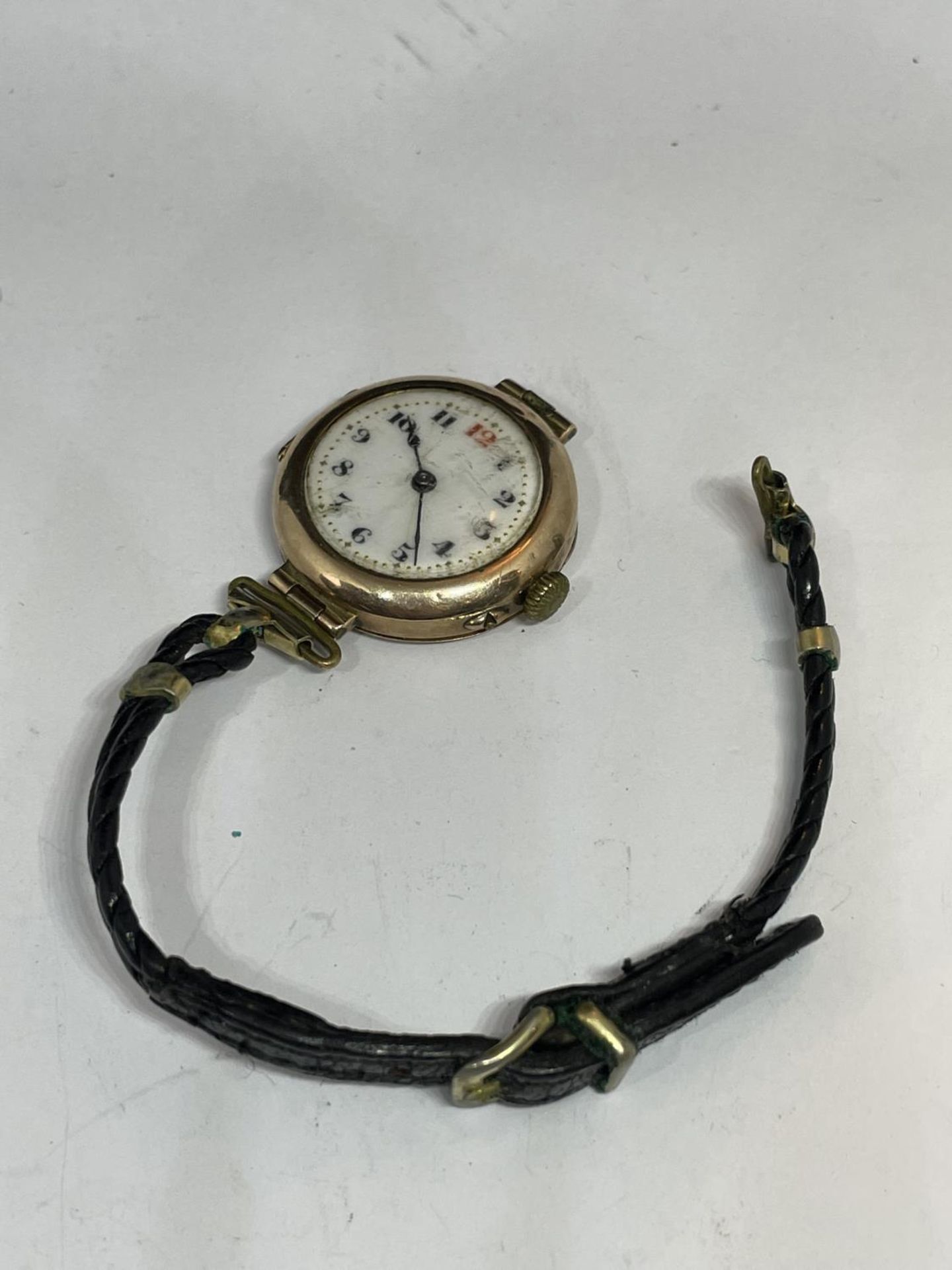 A MARKED 9 CARAT GOLD CASED WATCH WITH LEATHER STRAP IN NEED OF REPAIR