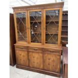 A MODERN YEW WOOD GLASED BOOKCASE ON BASE 56" WIDE