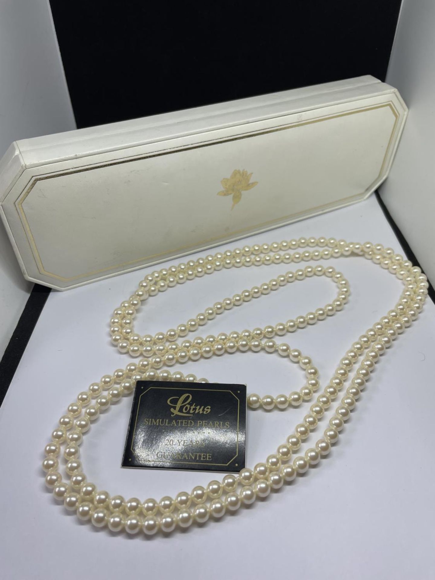 A LONG STRAND OF LOTUS PEARLS IN A PRESENTATION BOX