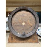 A VINTAGE OAK BANDED ALCOHOL BARREL ON STAND HEIGHT APPROX 34CM X LENGTH APPROX 35CM