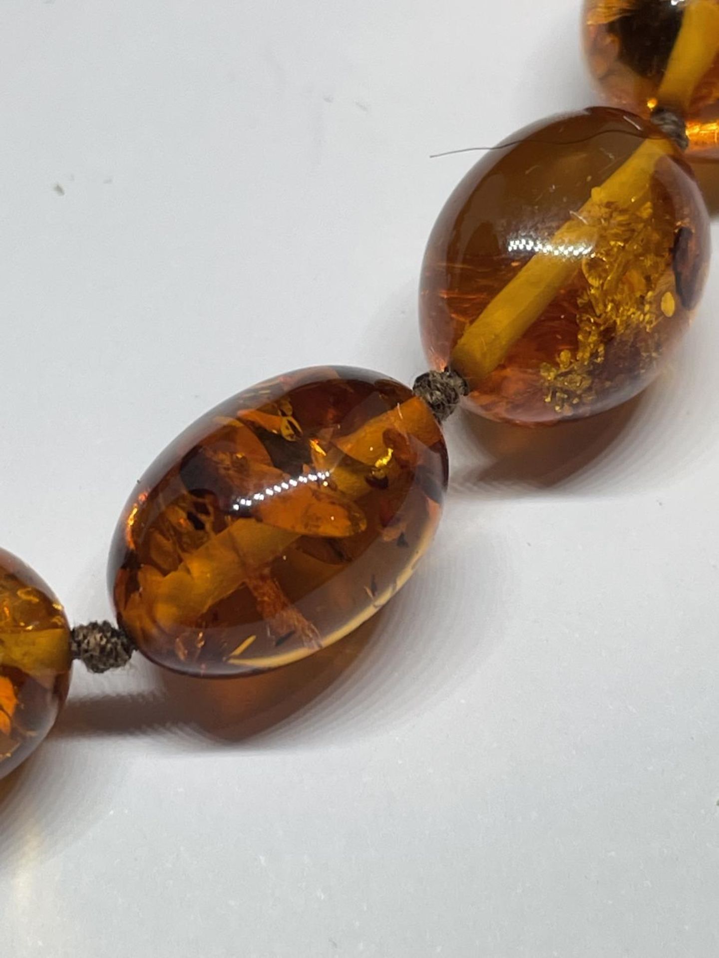 A KNOTTED AMBER NECKLACE WITH A MARKED 9K CLASP - Image 2 of 4