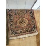 A LARGE SALMON AND BLUE PATTERN FRINGED RUG