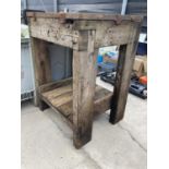 A WOODEN WORK BENCH WITH A HEAVY CAST IRON TOP 69CM X 61CM