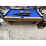 A WOODEN POOL TABLE COMPLETE WITH TWO SETS OF BALLS AND A CUE