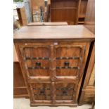 A 20TH CENTURY FOUR DOOR SHEESHAM CUPBOARD WITH CARVED DOORS AND APPLIED METALWARE DECORATION, 39"