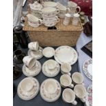 A WICKER BASKET CONTAINING A QUANTITY OF STEELITE CUPS, SAUCERS, PLATES, ETC