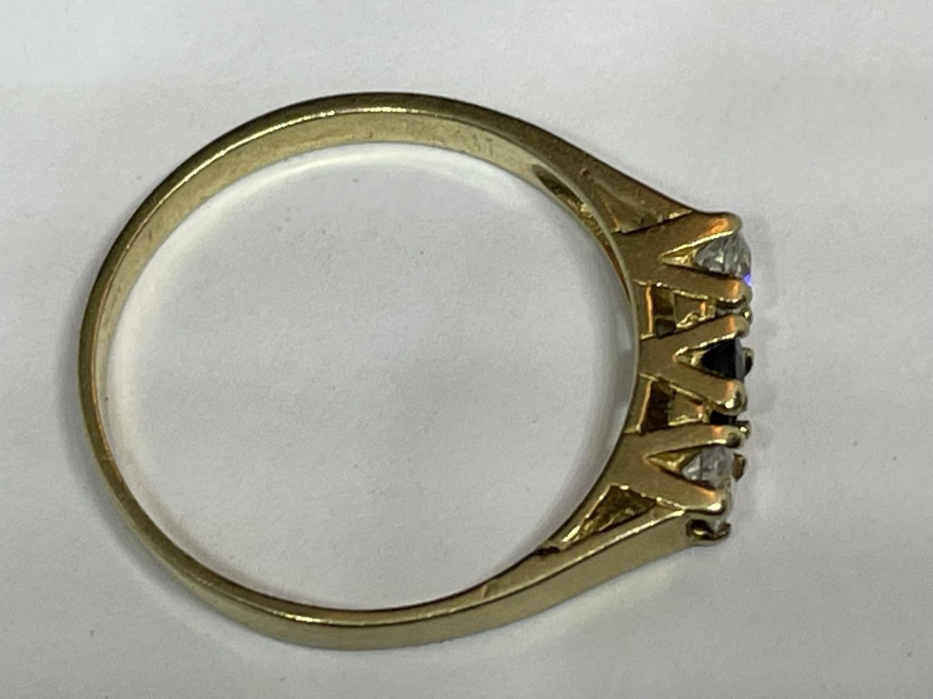 A 9 CARAT GOLD RING WITH THREE IN LINE STONES TO INCLUDE A CENTRE SAPPHIRE AND TWO CUBIC ZIRCONIAS - Image 7 of 8