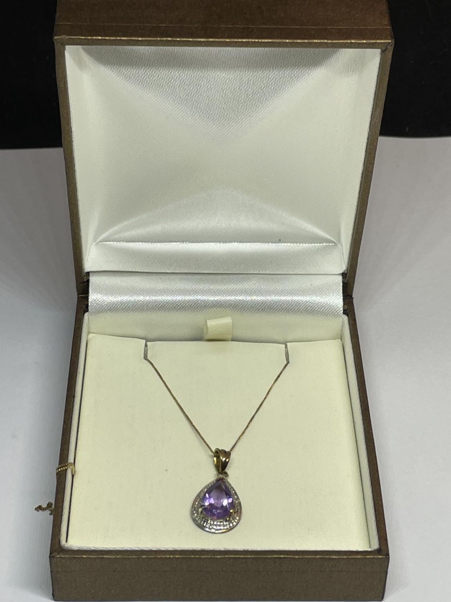 A 9 CARAT GOLD NECKLACE WITH AN AMETHYST PENDANT IN A PRESENTATION BOX