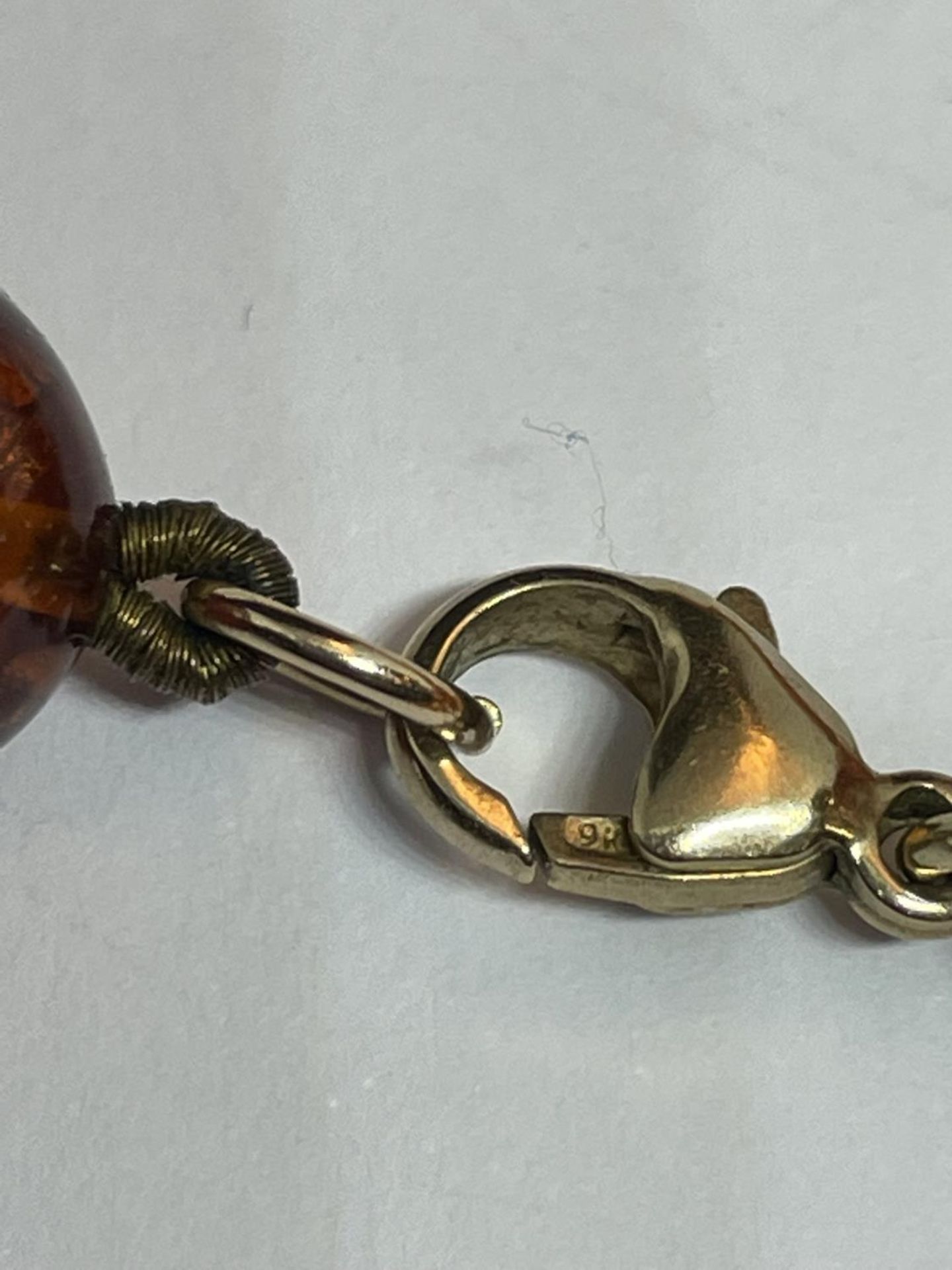 A KNOTTED AMBER NECKLACE WITH A MARKED 9K CLASP - Image 4 of 4