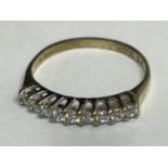 A 9 CARAT GOLD RING WITH NINE CUBIC ZIRCONIA IN LINE STONES SIZE H/I