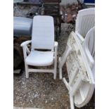 NINE WHITE PLASTIC GARDEN CHAIRS AND A TABLE