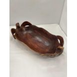AN AFRICAN HAND CARVED WOODEN OBLONG BOWL WITH TORTOISE HANDLES, HAS INITIALS TO THE UNDERNEATH,
