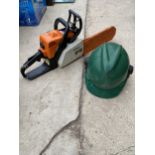 A STIHL PETROL CHAINSAW WITH A HARD HAT