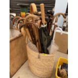 A WICKER BASKET WITH A LARGE QUANTITY OF WALKING STICKS