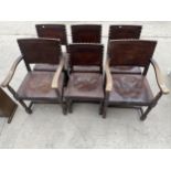 A SET OF SIX JACOBEAN STYLE OAK DINING CHAIRS WITH LEATHER STUDDED SEATS ON TURNED LEGS, TWO BEING