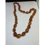 A KNOTTED AMBER NECKLACE WITH A MARKED 9K CLASP