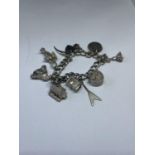 A MARKED SILVER CHARM BRACELET WITH TEN CHARMS TO INCLUDE A FLAMENCO DANCER, MATADOR, HOUSE, OIL