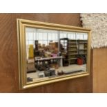 A DECORATIVE GILT FRAMED WALL MIRROR (106CM X 75CM)